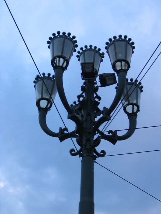 Pouliční osvětlení kombinované s dráty k napájení tramvají.